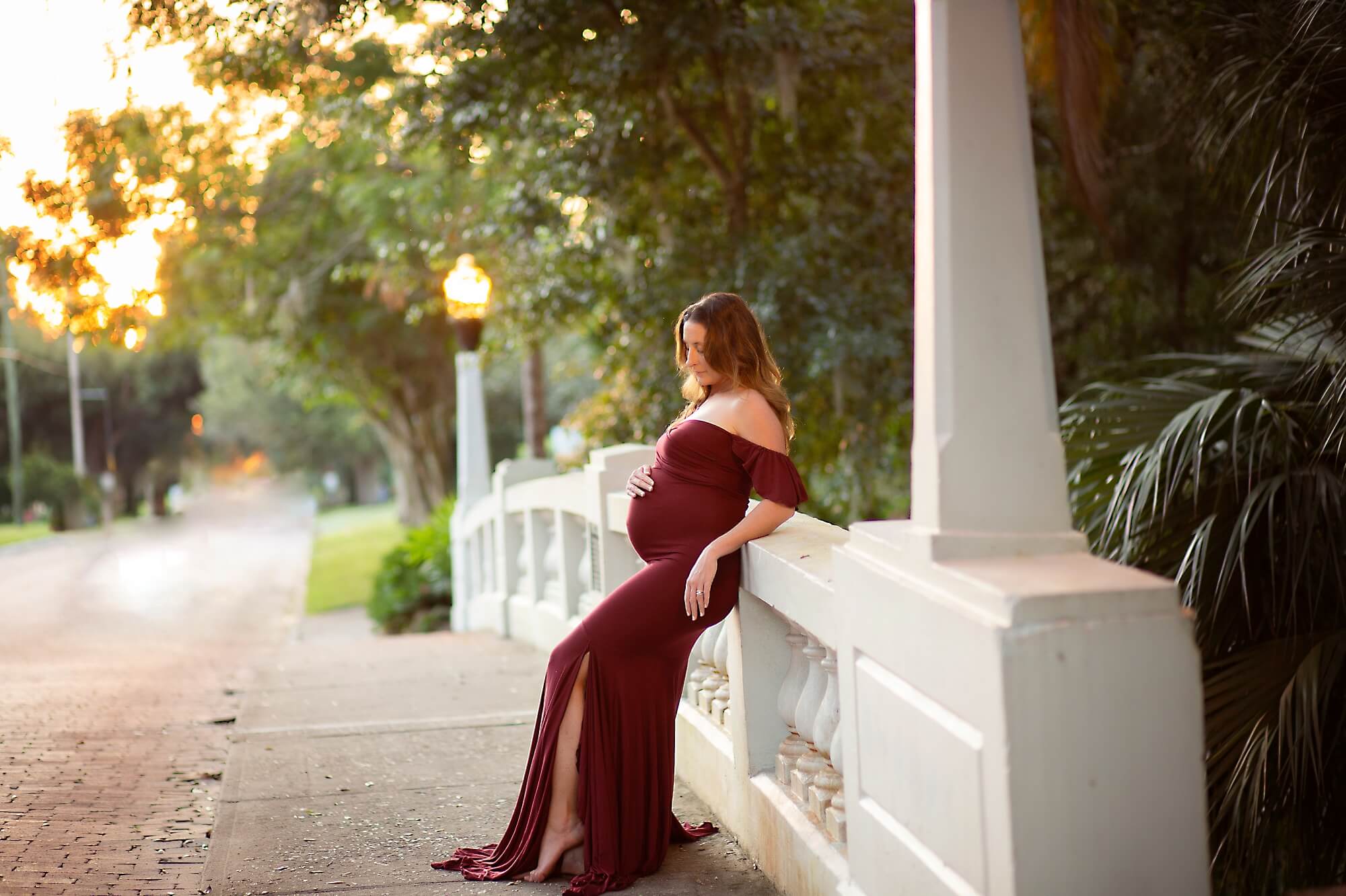 pregnant mom leaning on a bridge