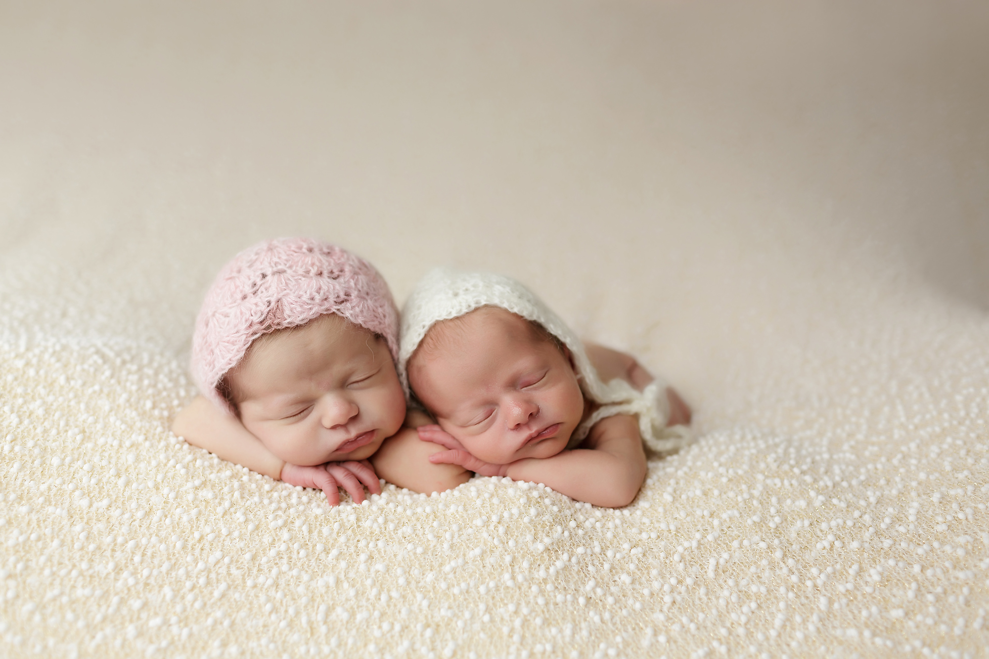 twin newborn girls posed together on blanket