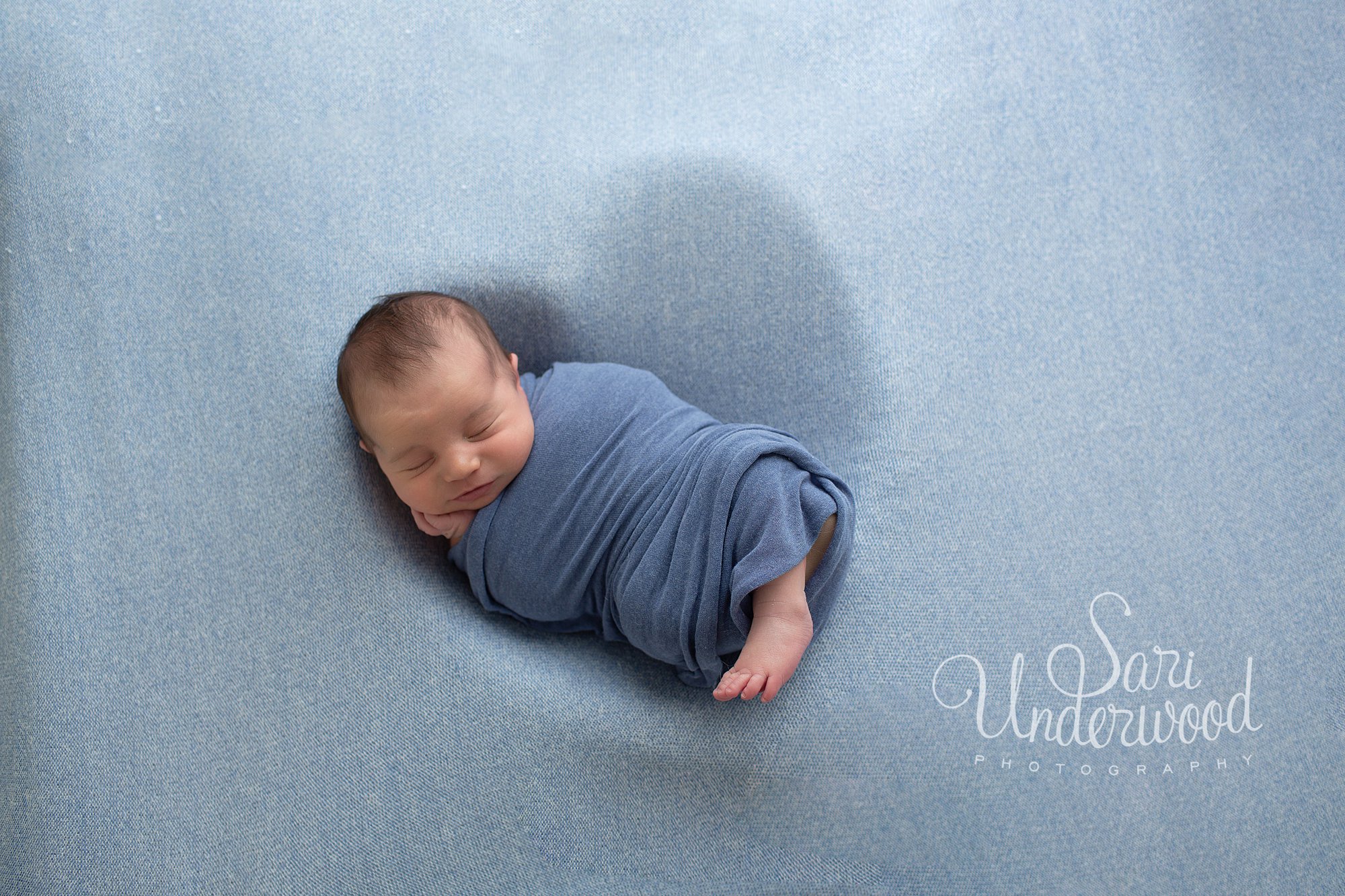newborn baby boy posed inside of a heart shape